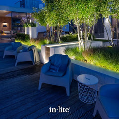 in-lite atmospheric garden lighting. in-lite EVO FLEX 12v outdoor surface lights installed under wall coping overhang running along raised planting beds filled with lush green ornamental grasses.  The EVO FLEX LED strip light is illuminating along the borders of the raised planting beds filled with lush green ornamental grasses.